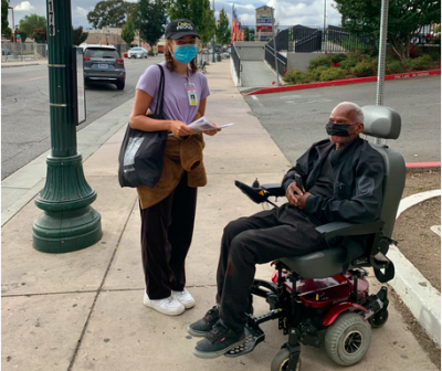 Woman standing and man in wheelchair