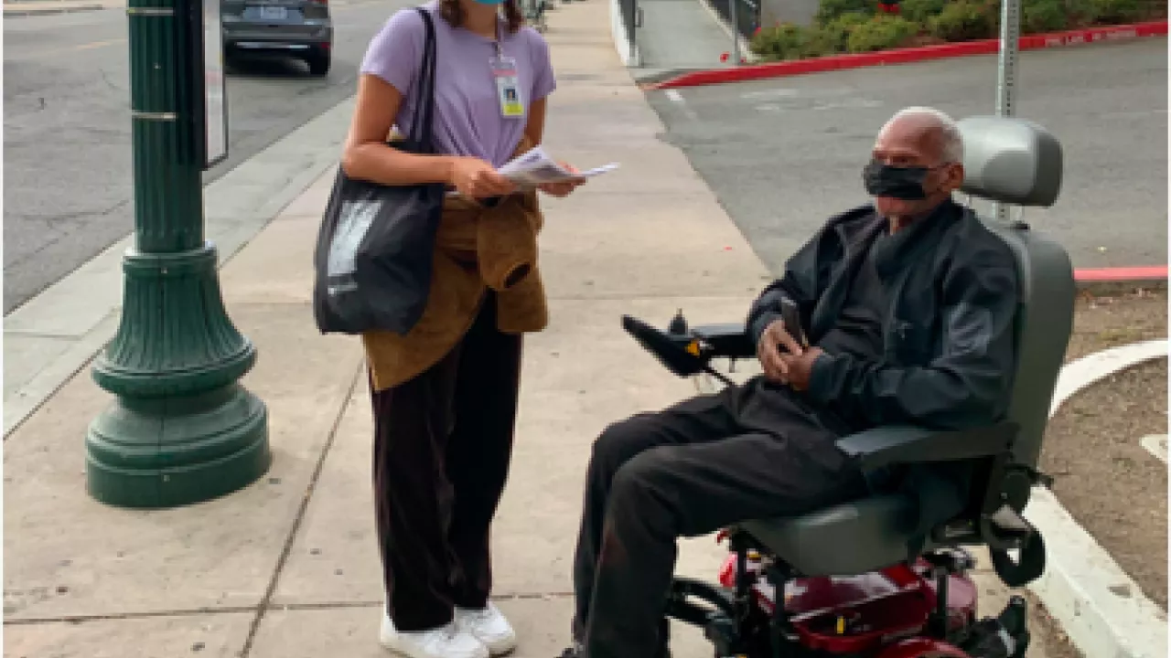 Woman standing and man in wheelchair