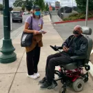 Woman standing and man in wheelchair